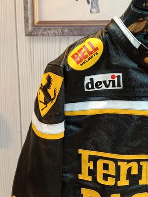 Close-up detail of the chest area showing the Bell Helmets, Devil, and Chesterfield sponsor patches on the black leather Ferrari jacket.