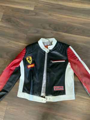 Front view of the black, white, and red leather Ferrari racing jacket with the prancing horse shield and Bridgestone patch.