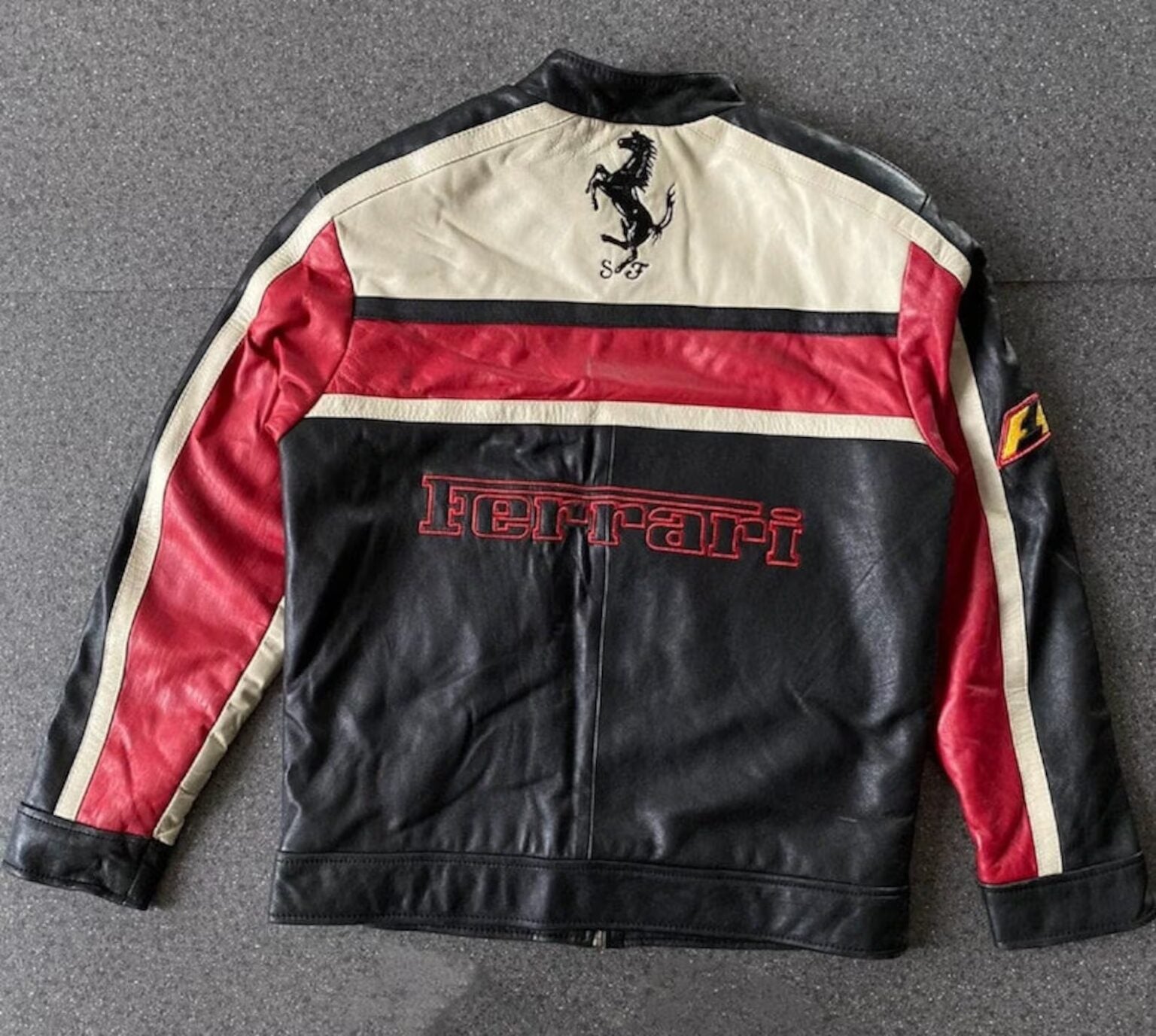 Back view of Ferrari F1 inspired leather jacket in black, red, and cream