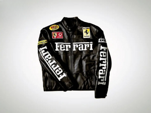 A black leather Ferrari Racing jacket with large white Ferrari text on the chest and sleeves, featuring small Bell, Vodafone, and Michelin sponsor patches.
