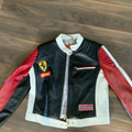 Front view of the black, white, and red leather Ferrari racing jacket with the prancing horse shield and Bridgestone patch.