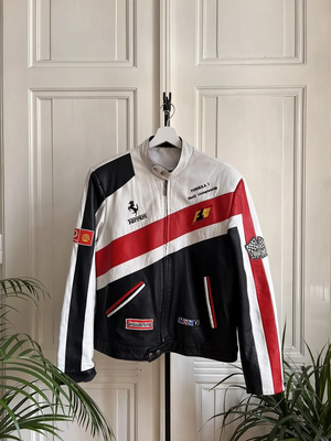 Front view of a white, black, and red leather Ferrari Formula 1 World Championship racing jacket with Bridgestone and Mobil 1 logos.