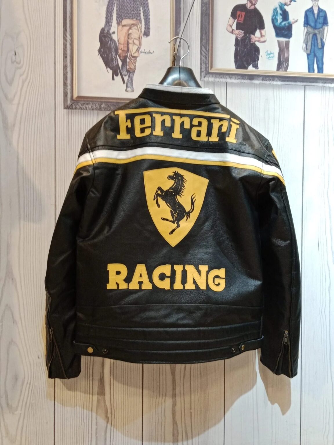 Back view of the black leather Ferrari jacket showing the large yellow Ferrari text, Scuderia logo, and RACING text below.