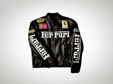 A black leather Ferrari Racing jacket with large white Ferrari text on the chest and sleeves, featuring small Bell, Vodafone, and Michelin sponsor patches.