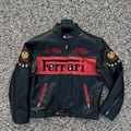 Front view of a black and red leather Michael Schumacher Ferrari F1 2004 World Champion jacket, with "Race to Win" text.