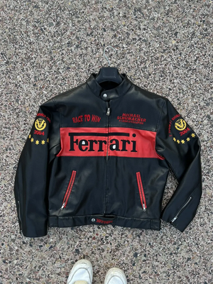 Front view of a black and red leather Michael Schumacher Ferrari F1 2004 World Champion jacket, with "Race to Win" text.