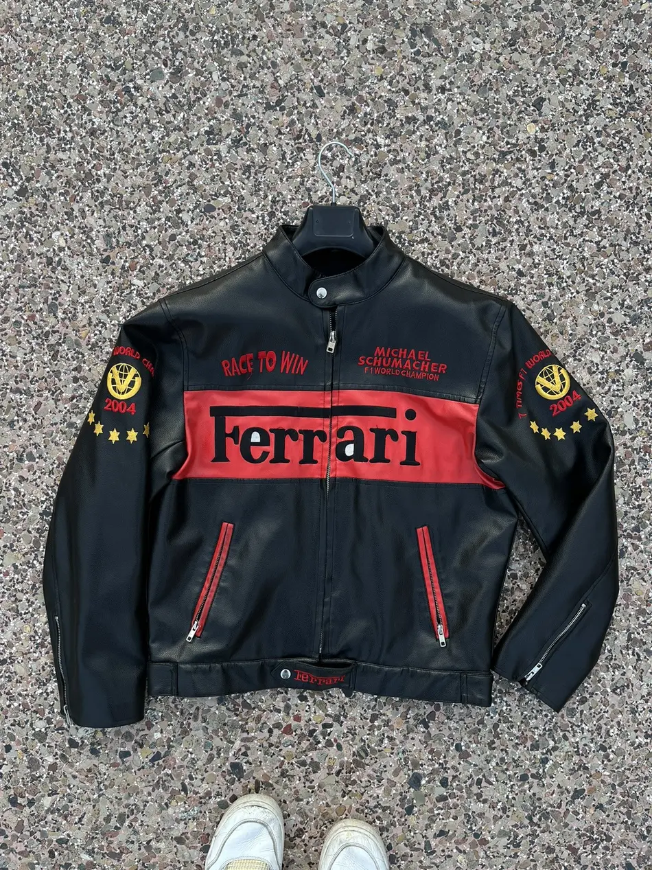 Front view of a black and red leather Michael Schumacher Ferrari F1 2004 World Champion jacket, with "Race to Win" text.